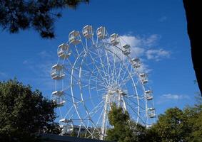 White ferris wheel against the blue sky. Ferris wheel in the park photo