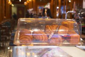 vertical sho or fresh baked croissant in a glass transparent container at shop photo