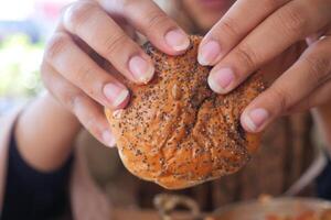 women hand pick baked bun on table photo