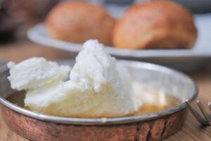 butter cream and honey in a bowl on table . photo