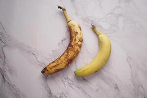 comparing rotten banana with a ripe banana on a white background photo