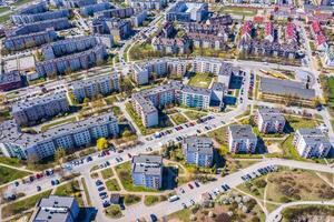 Aerial city view with crossroads and roads, houses, buildings, parks and parking lots. photo