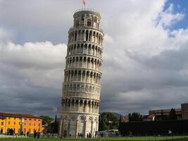 The famous Leaning Tower in Pisa on cloudy sky background photo