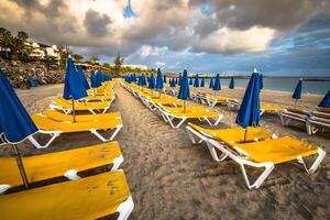 Beautiful sun loungers with parasols on the beach photo