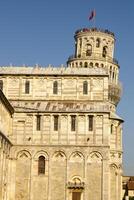 The famous Leaning Tower in Pisa on cloudy sky background photo