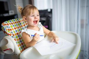 Cute little girl painting with felt-tip pen at home. Creative games for kids. Stay at home entertainment photo