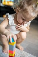 Caucasian child a little girl is playing in the constructor at home. Educational toys for children. photo