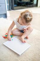 bonito pequeño niña jugando con seta uña mosaico a hogar. pasatiempo y ocio hora foto