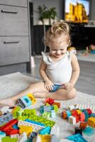 caucásico niño un pequeño niña es jugando en el constructor a hogar. educativo juguetes para niños. foto