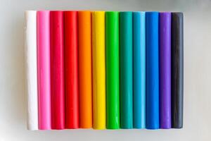 Multicolored pieces of plasticine are arranged vertically as a background. photo