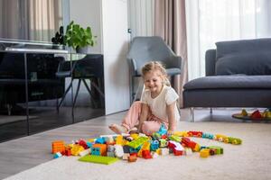 Little girl play with constructor toy on floor in home, educational game, spending leisure activities time concept photo