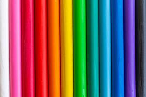 Multicolored pieces of plasticine are arranged vertically as a background. photo