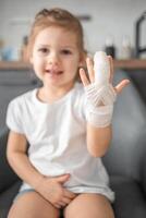 pequeño niña con roto dedo a el del doctor cita en el hospital foto
