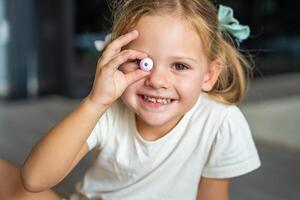 pequeño niña obras de teatro con talón haciendo de madera rosario pulsera. para niños creatividad y el desarrollo de multa motor habilidades foto