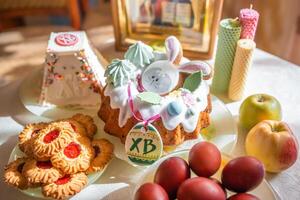 Pascua de Resurrección pastel con pintado huevos, manzanas y galletas en mesa en hogar cocina. Iglesia íconos y vela en antecedentes. ortodoxo religión tema. alto calidad foto