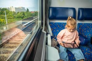 Beautiful Little girl using digital tablet during traveling by railway in Czech republic, Europe photo