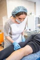 Medical female worker doing wound treatment and removing stitches photo