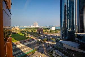 Abu Dhabi, United Arab Emirates - December 4, 2023. View from building of gate to the Emirates Palace hotel and Rixos hotel on background in Abu Dhabi, UAE. photo