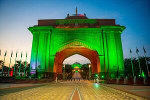 Abu Dhabi, United Arab Emirates - December 4, 2023. Arabic style gate to the Emirates Palace hotel light up at night in Abu Dhabi, UAE. High quality photo