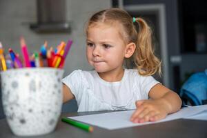 little girl draws with colored pencils in home. photo