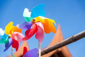 Multi-coloured windmill toys on blue sky background. High quality photo