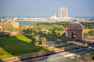 Abu Dhabi, United Arab Emirates - December 4, 2023. Aerial view of gate to the Emirates Palace hotel and Rixos hotel on background in Abu Dhabi, UAE. photo