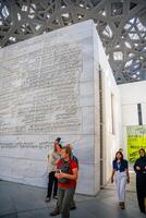 Abu Dhabi, UAE - December 6, 2023. Interior of Louvre and Visitors looking at exhibits, museum in Abu Dhabi, UAE photo