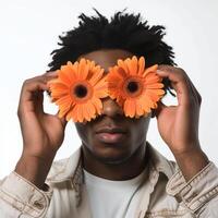 ai generado africano americano hombre cubre ojos con dos naranja gerberas foto