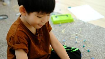 asiatico ragazzo giocando con plastilina nel il camera video