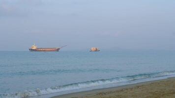 An old cruise ship floating in the middle of the sea near the beach. video