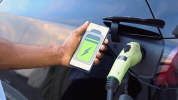 Black man uses a mobile application to control the battery of an electric car video