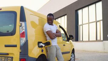 African american deliveryman at electro charging station near cargo electric car video