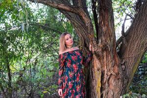 Lady under a big willow tree. Woman in a dress. photo