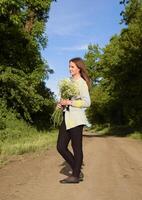 Young beautiful girl with a bouquet of chamomiles. A woman in a photo