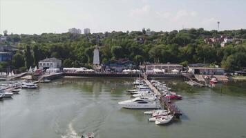 Luxury yachts in harbor at evening. Sailing on the sea aerial view. Sailing boats and yachts at sunset aerial view. Port at sunset, with a beautiful sky and forest in the background video