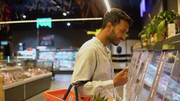 Indian man buys a uncooked smoked sausage in the supermarket video