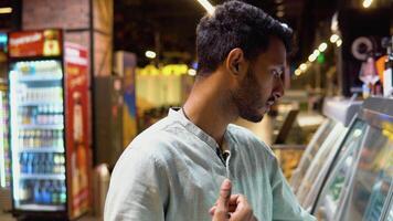 Indian man shopping for fresh salmon fish seafood in supermarket retail store video