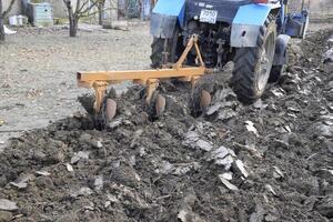 Tractor plowing the garden. Plowing the soil in the garden photo