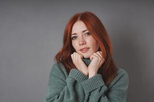 young woman snuggling into warm turtleneck sweater photo
