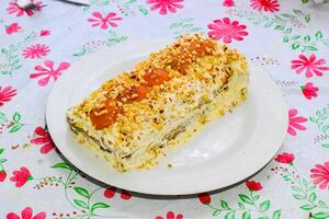 Cake with cream, apricot, sprinkled with nuts photo