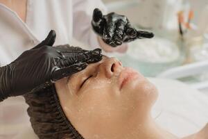 Facial peeling, spa treatments, skin care. A woman receiving facials from a cosmetologist at a spa, close-up photo