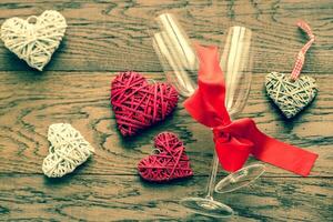 Two flutes with retro cane hearts on the wooden background photo