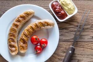 Grilled sausages with tomato and mustard sauce photo