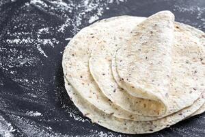 Stack of tortillas on a black surface photo