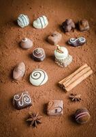 Luxury chocolate candies with cocoa background photo