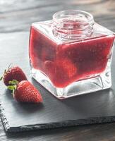 Glass jar of strawberry jam photo