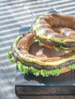 Bagels with fresh lettuce and fried sausage photo
