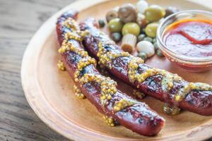 Grilled sausages with marinated vegetables photo