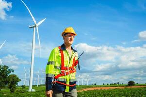 Engineer inspects wind turbine at wind farm for maintenance photo