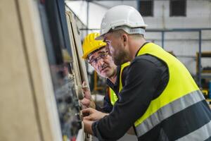 dos ingeniero Mira proyectos y planificación con tableta móvil en fábrica foto